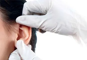 doctor in white gloves inspect patient ears